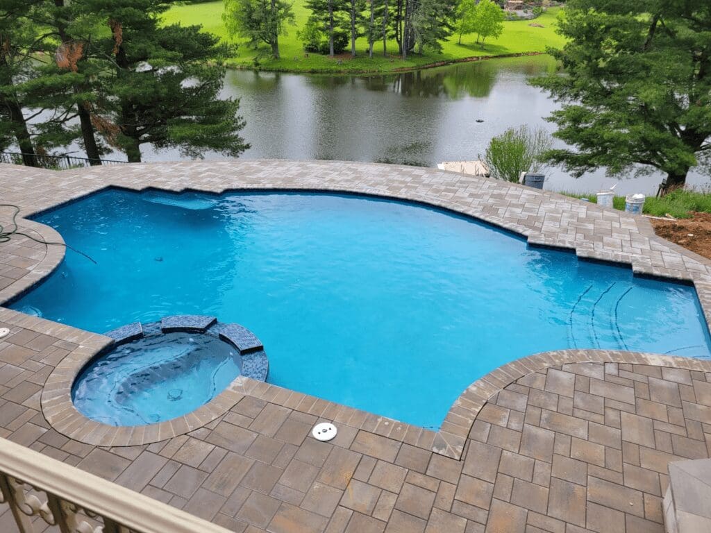 Blue pool and spa overlooking a lake